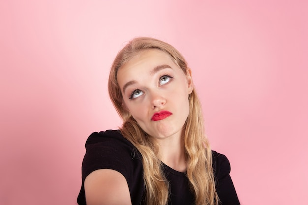 Free photo young emotional woman on pink studio background. human emotions, facial expression concept.