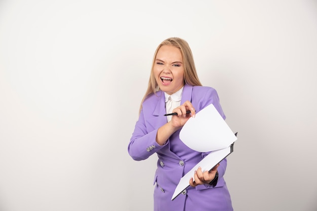 Young emotional woman with pencil and tablet on white.