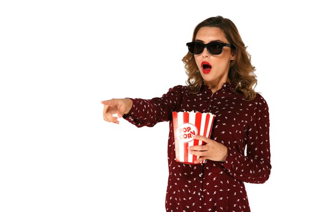 Young emotional woman with popcorn watching action movie in 3d glasses