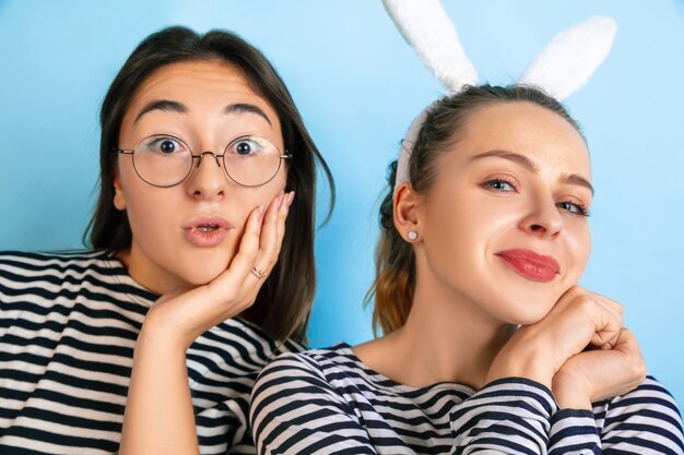 Young emotional women isolated on gradient blue studio wall