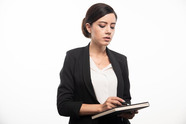 Young employee checking notebook on white background. High quality photo