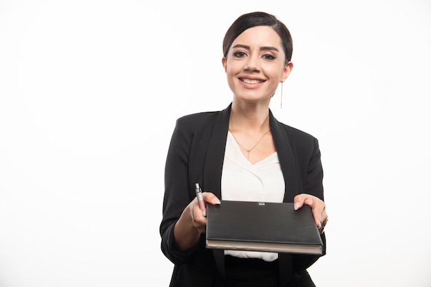 Young employee giving notebook on white background. High quality photo