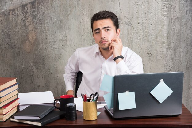 Young employee posing at the office desk.