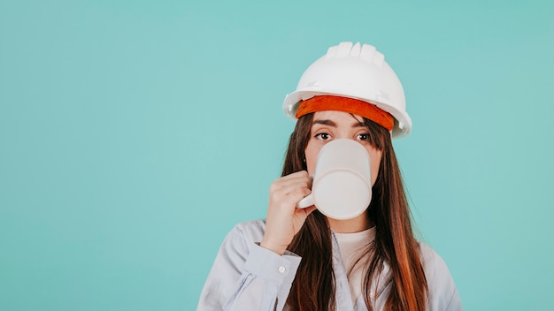 Young engineer drinking hot beverage