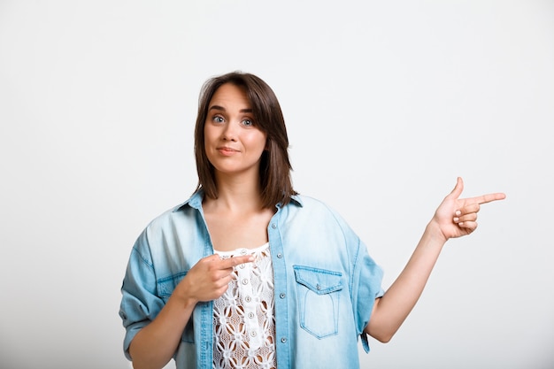 Foto gratuita giovane donna entusiasta che punta a destra