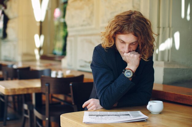 カフェで新聞を読む若い起業家