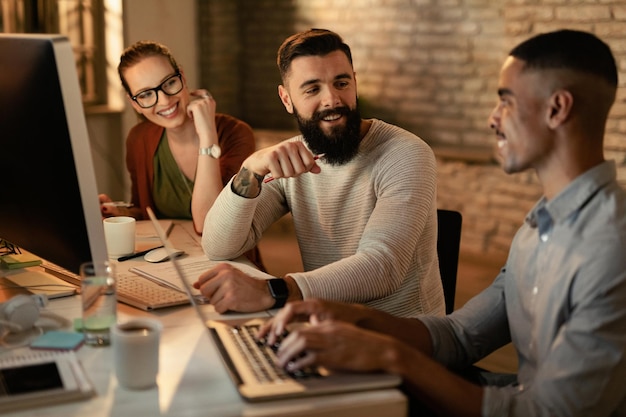 Young entrepreneurs working late and communicating in the office Focus is on man with beard