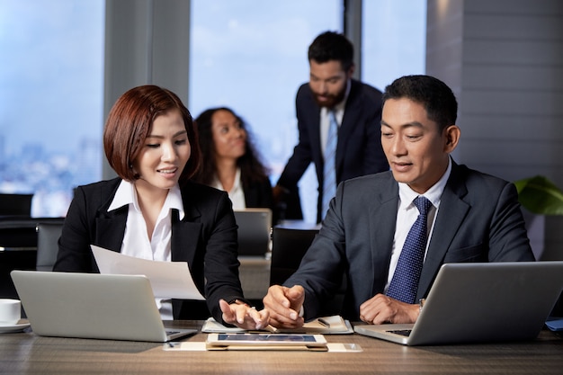 Young ethnic coworkers using tablet