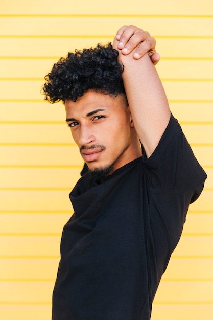 Free photo young ethnic man stretching arms above