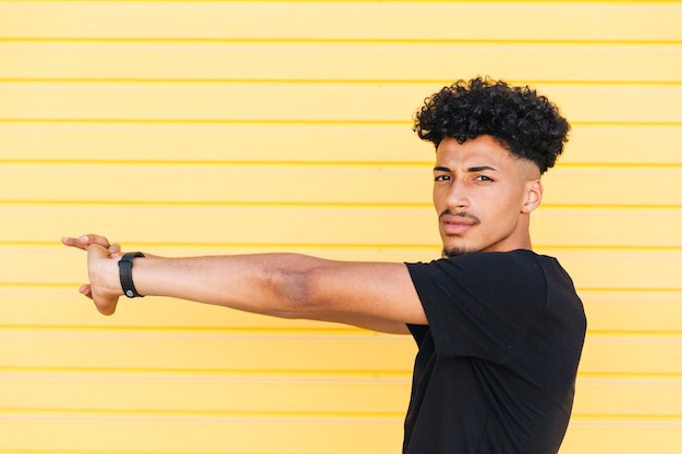 Young ethnic man stretching arms