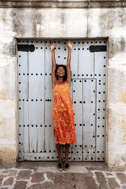 Young ethnic woman standing near old door