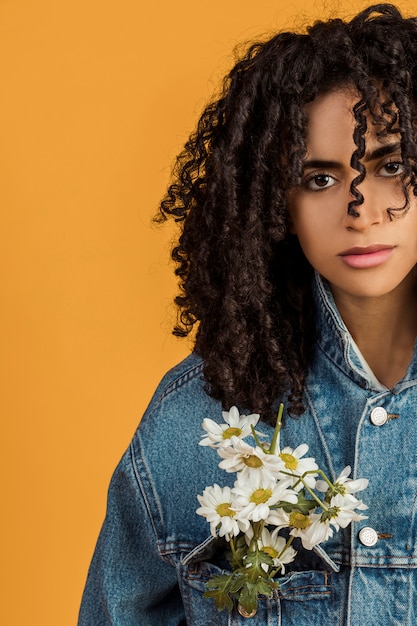 Young ethnic woman with flowers on jean jacket