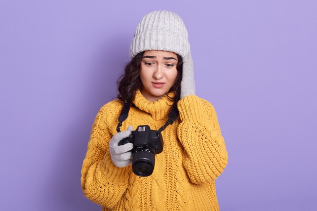 Young European female against lilac wall