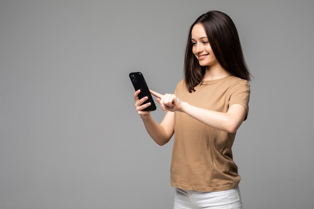 Young european student scrolling news feed in her smartphone with concentrated expression