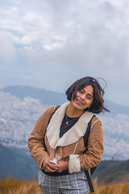 Young excited female hiking in mountains and enjoying the beautiful view