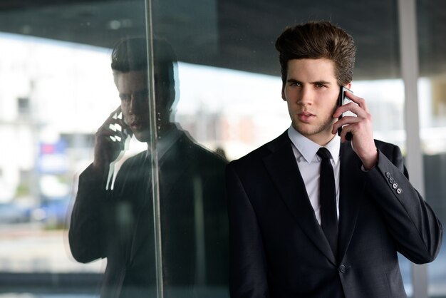 Young executive in black suit talking on the phone