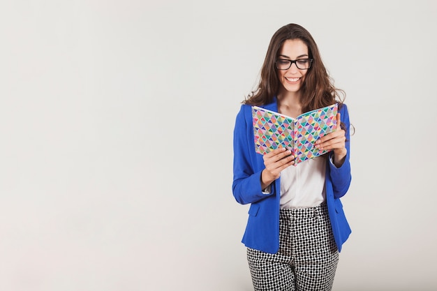 Free photo young executive smiling and reading a notebook