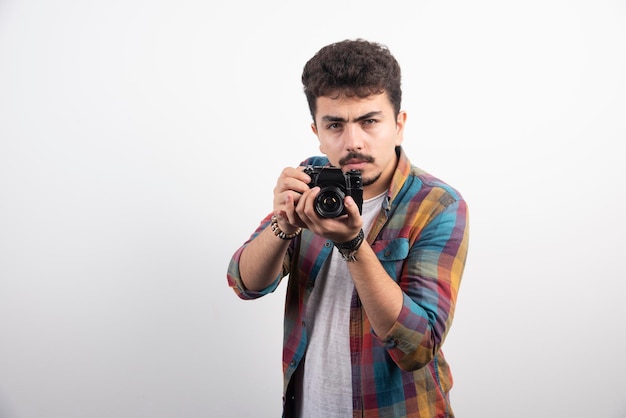 Young experienced photograph taking professional photos in a serious manner.