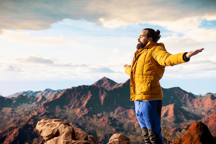 Free Photo young explorer reaching the mountain peak and meditating at the top