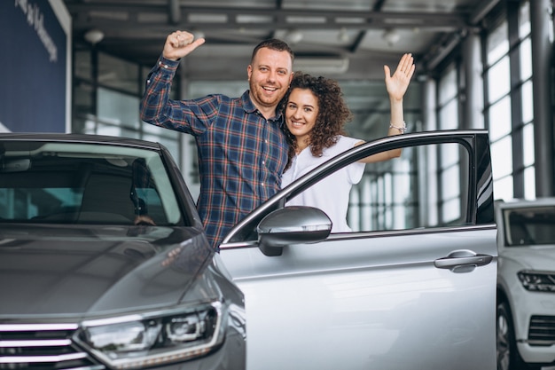 Free photo young family buying a car in a car showroom