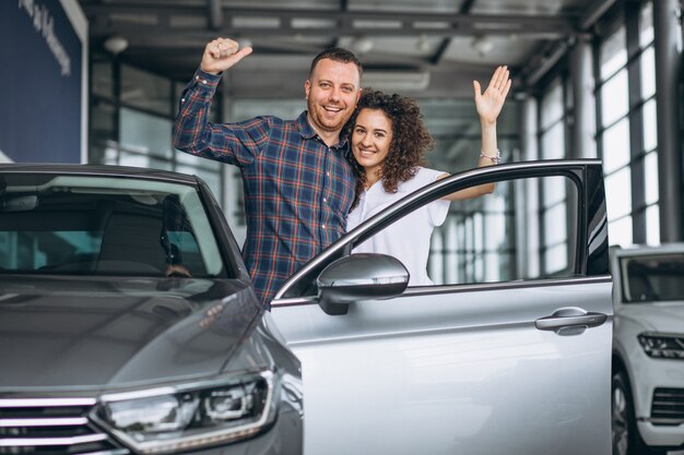 Young family buying a car in a car showroom