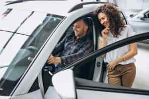 Free photo young family choosing a car in a car showroom