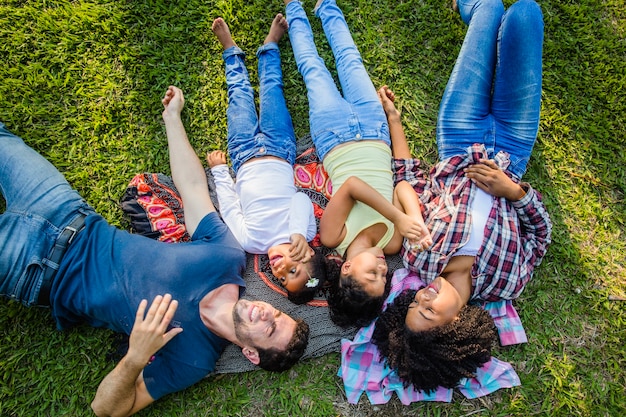 Young family lying together on the grass