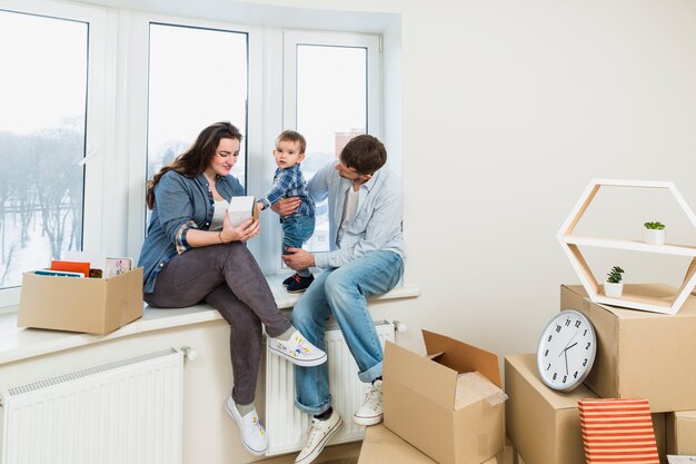Young family relaxing in their new home with moving cardboard boxes