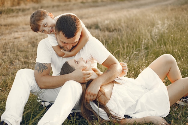 Young family sitting on a grass together in a sunny day.