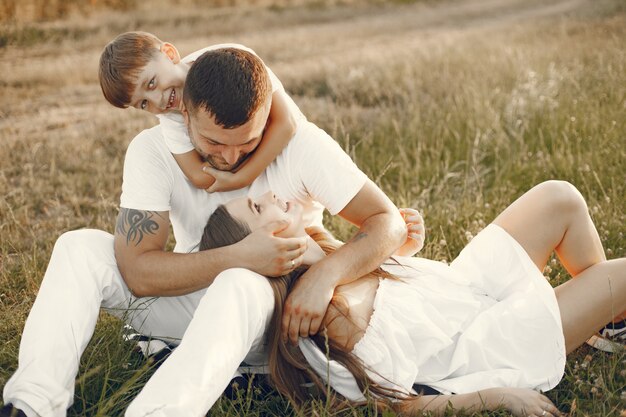 無料写真 晴れた日に一緒に草の上に座っている若い家族。