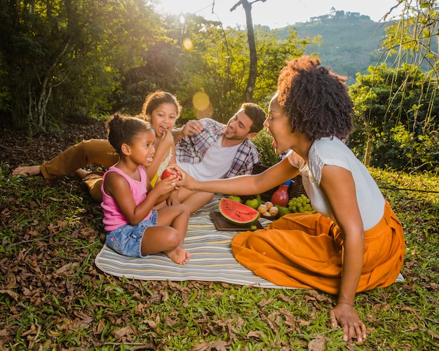 Foto gratuita giovane, famiglia, seduta, picnic, stoffa