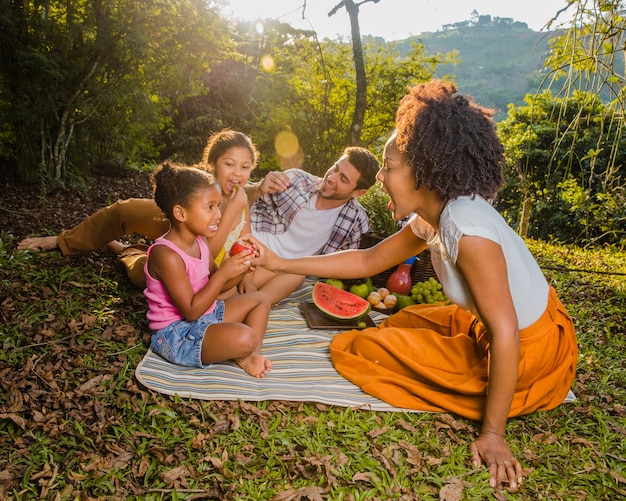 Young family sitting on picnic cloth