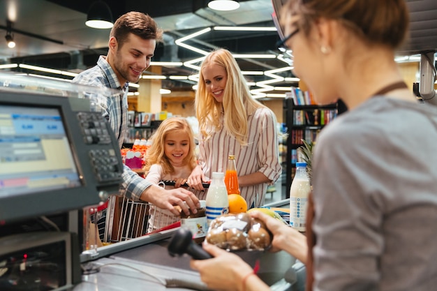 Free photo young family standing at the cash counter