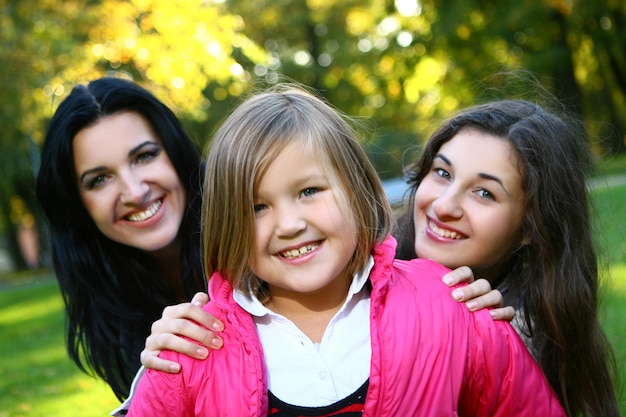 Giovane famiglia che fa passeggiata sana attraverso il parco di autunno