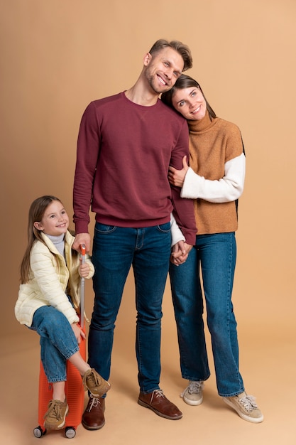 Young family of three posing together before travel vacation