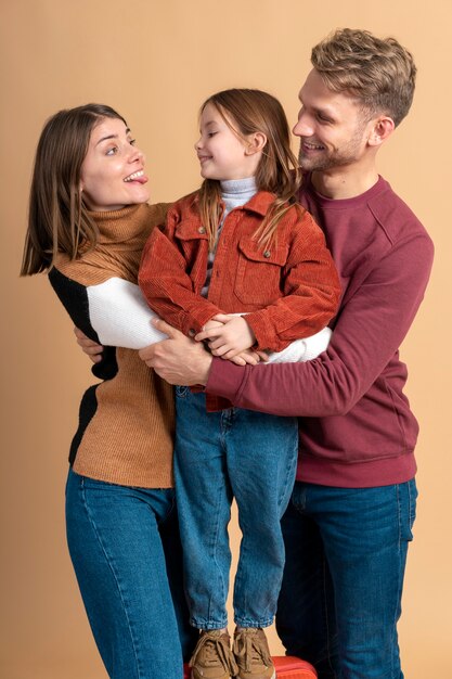 Young family of three posing together before traveling