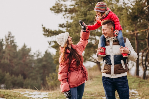 Young family together walking in forest at winter time