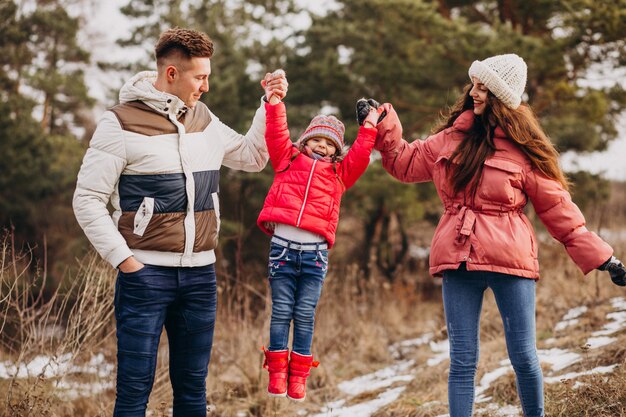 Young family together walking in forest at winter time