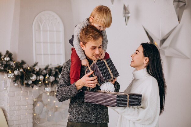 Young family unpacking gifts with little son on Christmas