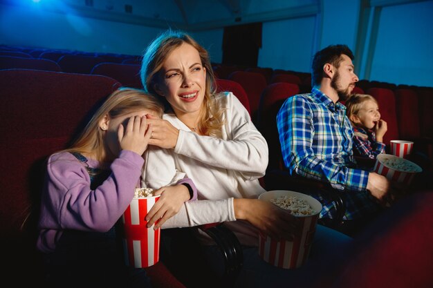 Молодая семья смотрит фильм в кинотеатре