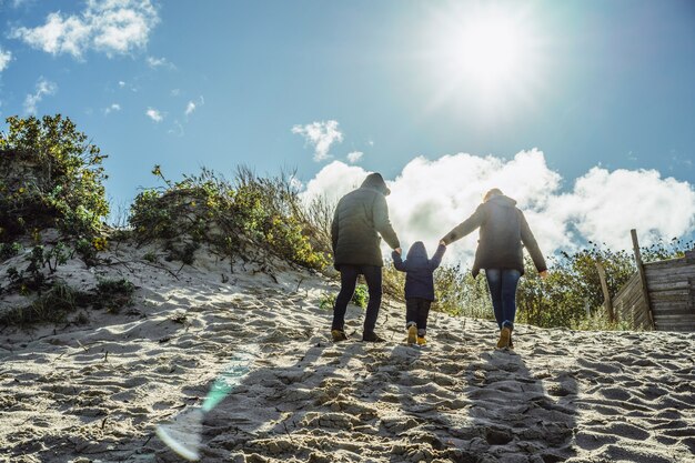 子供がいる若い家族は、冷たいバルト海の海岸で週末を過ごす