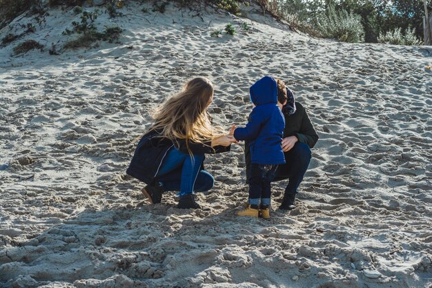 子供がいる若い家族は、冷たいバルト海の海岸で週末を過ごす