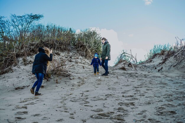 子供がいる若い家族は、冷たいバルト海の海岸で週末を過ごす