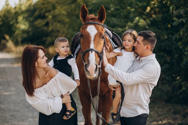 Молодая семья с детьми весело с лошадью в лесу