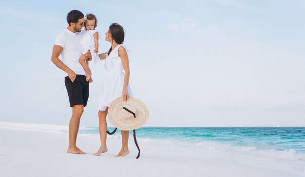 Young family with little daugher on a vacation by the ocean