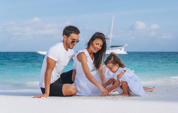 Молодая семья с маленькой дочкой на отдыхе у океана