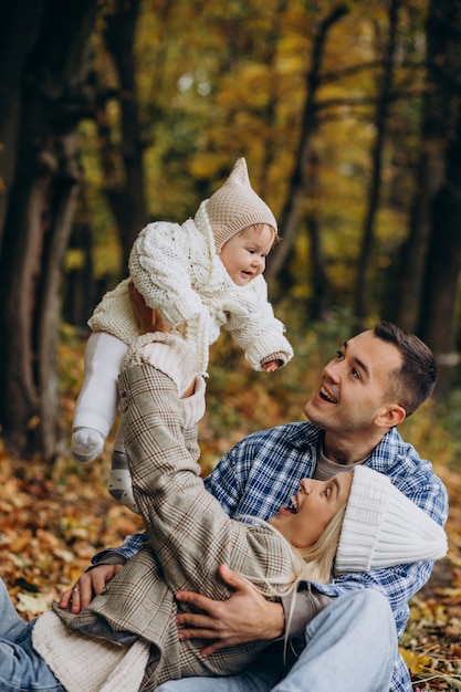 Young family with little daughter in autumn park