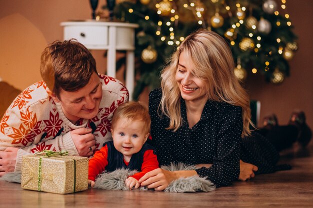 Young family with little daughter holding Christmas presents