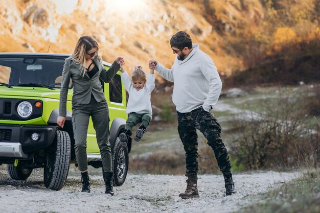 Free photo young family with little daughter stopped in forest