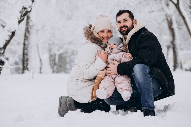 雪だらけの冬の森で幼い娘と若い家族